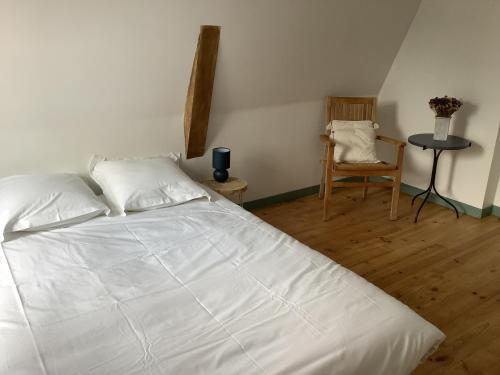 une chambre avec un lit blanc et une chaise dans l'établissement L’appart, à Bondues