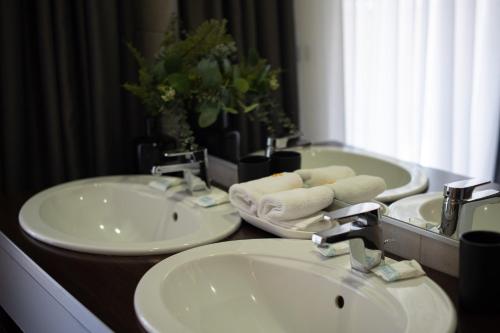 a bathroom with two sinks and a mirror at Silver Mountain Resort & Spa in Poiana Brasov