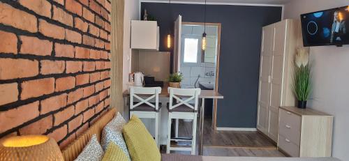 a living room with a brick wall and a kitchen at NORTH in Jastrzębia Góra