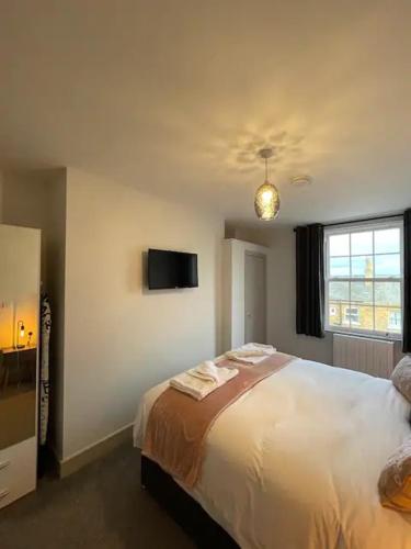 a bedroom with a bed and a tv on the wall at Superb 2 Bedroom Sea View Flat in Scarborough
