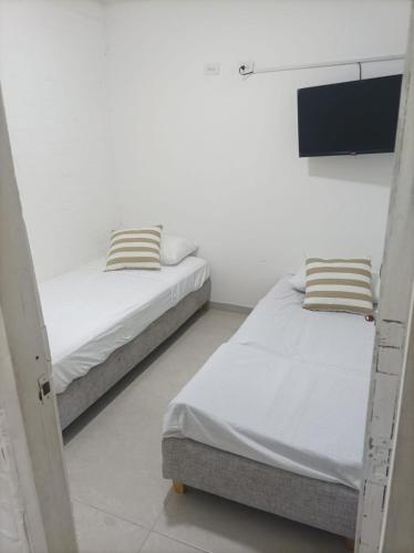 Postel nebo postele na pokoji v ubytování Hostal Catalleya