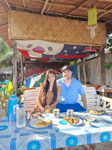 a man and woman sitting at a table with food at 8 Star Paradise in Locaroc