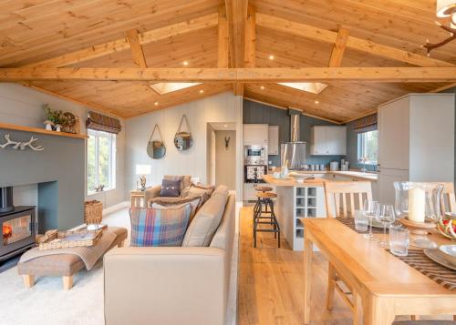 a living room and kitchen with a couch and a table at Thirlestane Woodland Lodges in Lauder