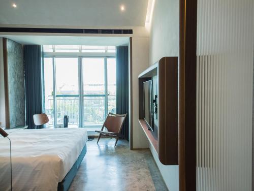 a hotel room with a bed and a television at PAPO'A Harbor Hotel in Kaohsiung