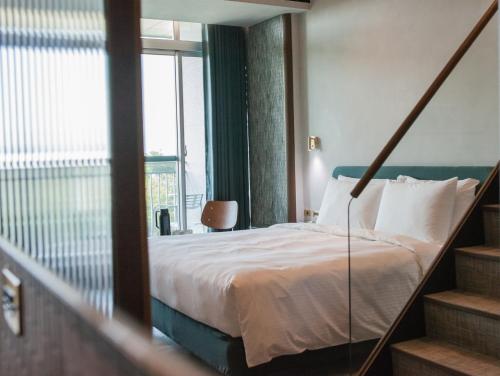 a bedroom with a bed and a large window at PAPO'A Harbor Hotel in Kaohsiung