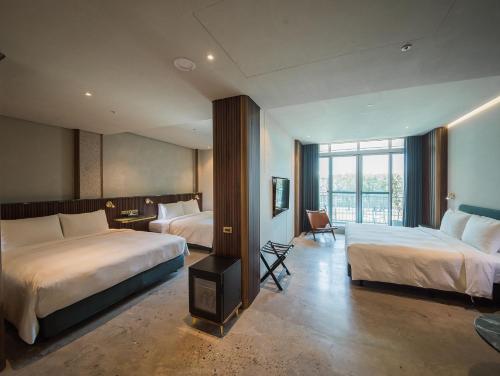 a hotel room with two beds and a large window at PAPO'A Harbor Hotel in Kaohsiung
