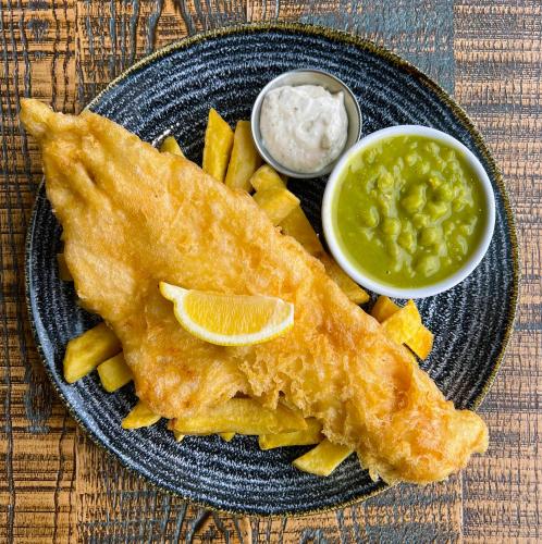 a plate of food with fish and chips and dip at The Pheasant Inn in Grange Over Sands