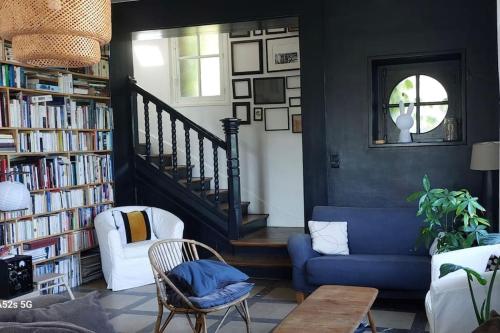 - un salon avec un canapé bleu et une étagère à livres dans l'établissement Maison ancienne de 170 m2, à Margny-lès-Compiègne