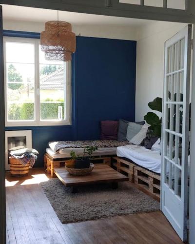 un salon avec un mur bleu et une table dans l'établissement Maison ancienne de 170 m2, à Margny-lès-Compiègne
