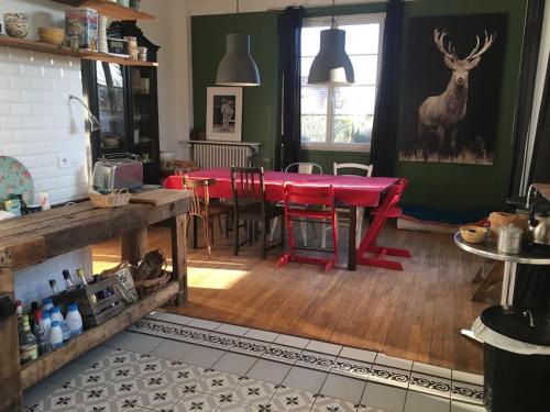 une salle à manger avec une table et des chaises rouges dans l'établissement Maison ancienne de 170 m2, à Margny-lès-Compiègne