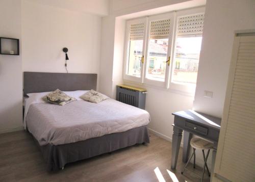 1 dormitorio con cama, escritorio y ventana en Rooftop Appia antica, Attico silenzioso residenziale, en Roma
