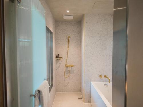 a bathroom with a shower and a tub and a sink at PAPO'A Harbor Hotel in Kaohsiung