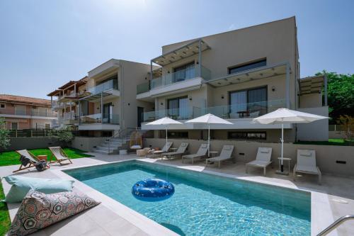 an apartment with a swimming pool in front of a building at Arodo Suites in Iraklitsa