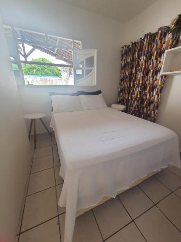 ein weißes Bett in einem Zimmer mit Fenster in der Unterkunft Casa de Campina in Campina Grande