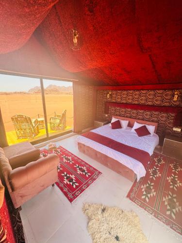 a bedroom with a bed and a large window at Desert Bedouin adventure in Wadi Rum
