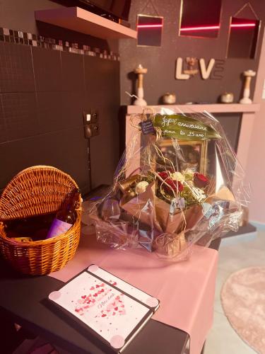 une table avec un panier et un téléphone portable dans l'établissement SPA bulles du paradis love room, à Berck-sur-Mer