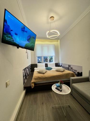 a bedroom with a bed and a flat screen tv on the wall at Centroom boutique hotel in Yerevan