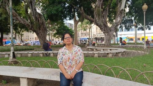 a woman sitting on a bench in a park at Eden Thottam Homestay in Kattappana
