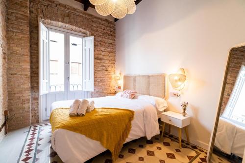 een slaapkamer met een groot bed en een spiegel bij Ma&to Alhóndiga Apart in Granada