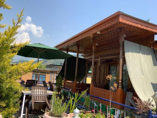 a house with a patio with a table and an umbrella at Movie land group of house boats in Srinagar