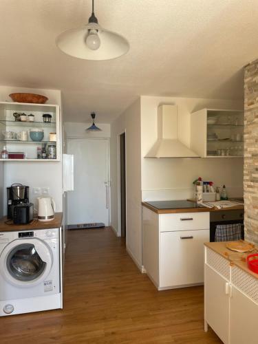 une cuisine avec une machine à laver dans une cuisine dans l'établissement Sanary charmant appartement bord de mer, à Sanary-sur-Mer