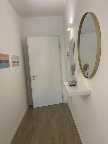 a white room with a mirror and a white door at Residenza Tramontana in Elmas