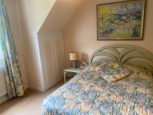 une chambre avec un lit et un tableau au mur dans l'établissement Villa Sabloyats, à Neufchâtel-Hardelot