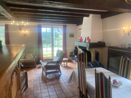 - un salon avec une cheminée, une table et des chaises dans l'établissement Villa Sabloyats, à Neufchâtel-Hardelot