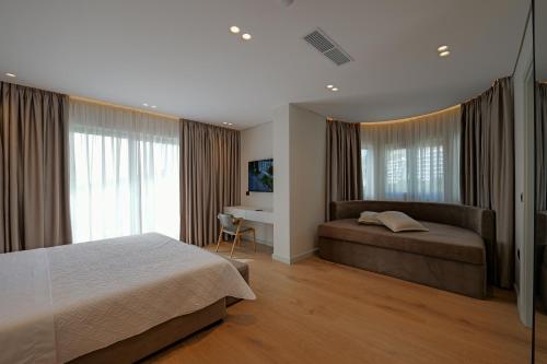 a bedroom with a bed and a desk and window at Hotel Teuta in Sarandë