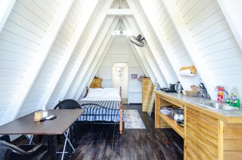 a room with a sink and a bed in a attic at Cashaw Cabin - Private A-frame Treasure Beach in Treasure Beach
