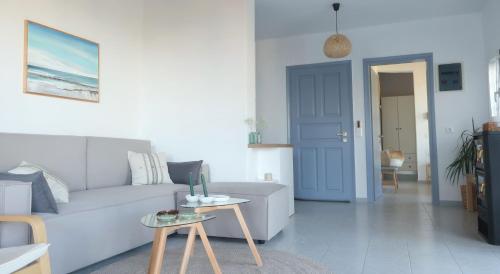 a living room with a white couch and a blue door at Onar House I in Achladies