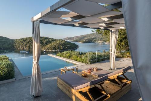 a room with a view of the water and a bed at Domotel Agios Nikolaos Suites Resort in Sivota
