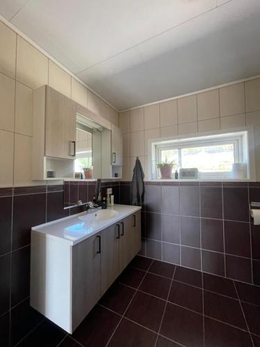 a large bathroom with a sink and a window at Island life! 2,5 bedroom house. in Vigra