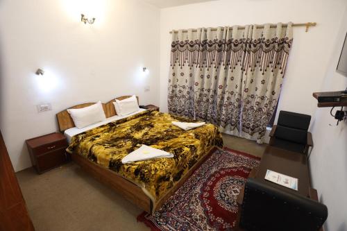 1 dormitorio con 1 cama, mesa y sillas en Hotel Jan Palace, en Leh