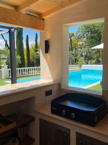 uma cozinha com piscina vista através de uma janela em Le Mas de l'Alliance - 12 p - Air Cond - private Pool - near Grignan em Roussas