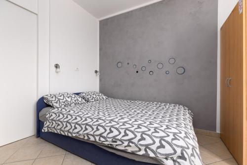 a bedroom with a bed with a black and white comforter at Studio with terrace & sea view in Vrsar