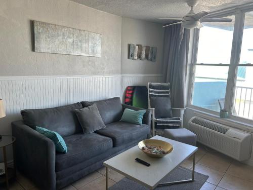 a living room with a couch and a table at Luxury Beach Condo with Pool and Tiki Bar! in Daytona Beach