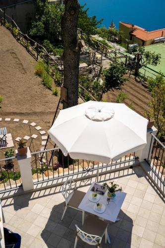 a table with a white umbrella on a patio at Dimora GiuEla in Positano