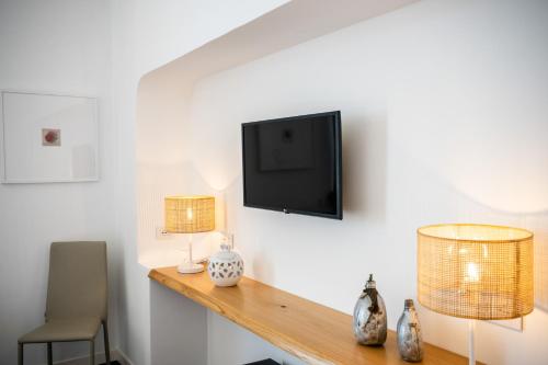 a room with two lamps and a television on a wall at Dimora GiuEla in Positano