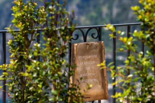 a sign on a fence with trees in the background at Dimora GiuEla in Positano