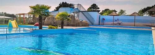 une grande piscine avec un toboggan aquatique dans l'établissement La Paranthese Marine, à Brem-sur-Mer