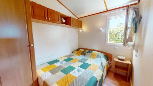 une petite chambre avec un lit et une fenêtre dans l'établissement La Paranthese Marine, à Brem-sur-Mer