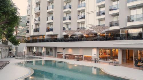 a hotel with a swimming pool in front of a building at Kleopatra Dreams Beach Hotel in Alanya