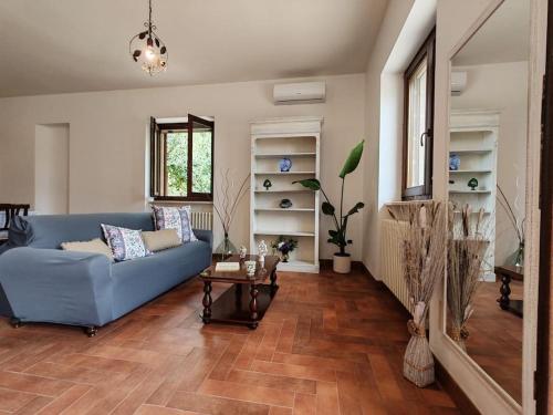uma sala de estar com um sofá azul e uma mesa em Villa Petra em Botrugno