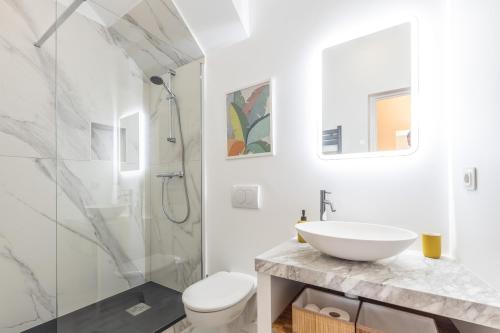 une salle de bain blanche avec un lavabo et une douche dans l'établissement Menton Old Town, à Menton
