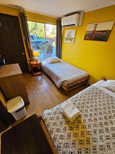 una camera da letto con due letti e una porta con una finestra di Hostal Radal Molina a Molina