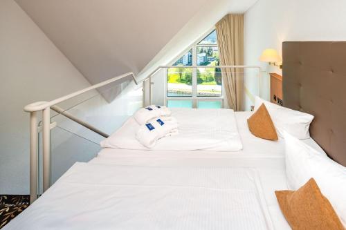 Best Western Ahorn Hotel Oberwiesenthal – Adults Only في كورورت أوبرفايسنتال: غرفة نوم بسريرين ونافذة