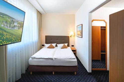 a hotel room with a bed and a painting on the wall at Best Western Ahorn Hotel Oberwiesenthal – Adults Only in Kurort Oberwiesenthal