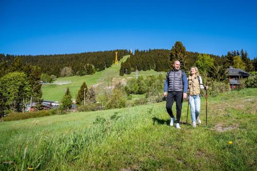 a man and a woman walking down a hill at Best Western Ahorn Hotel Oberwiesenthal – Adults Only in Kurort Oberwiesenthal
