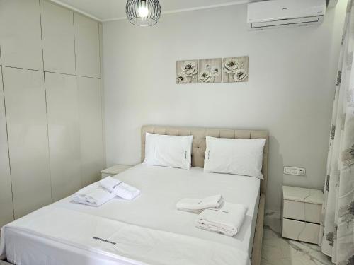 a white bedroom with a bed with towels on it at GREY LUXURY HOUSE in Ýpsos